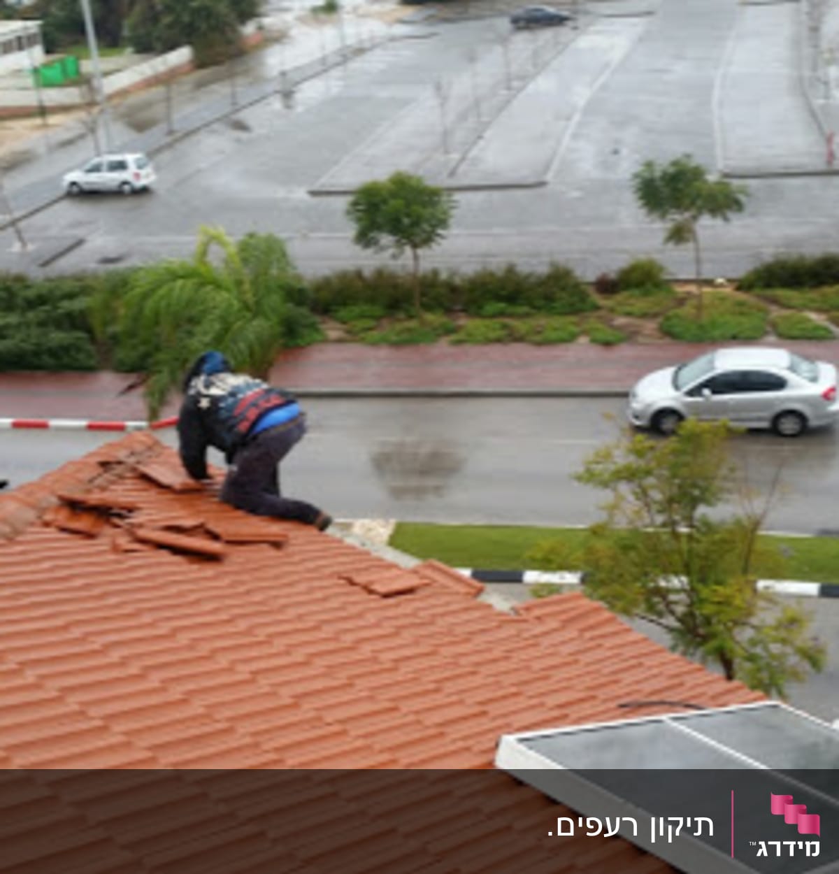 אדם מתקן רעפים על גג רעפים אדום